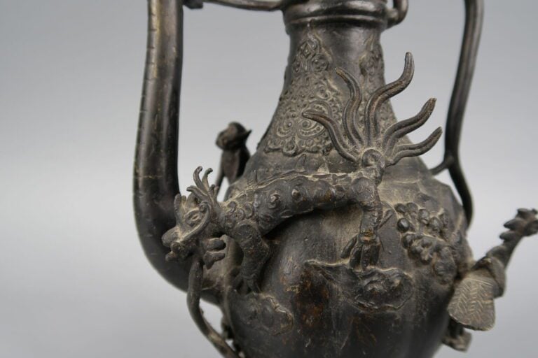 Chine - Verseuse en bronze à décor en relief de phénix, qilin, singe ... Le pie…