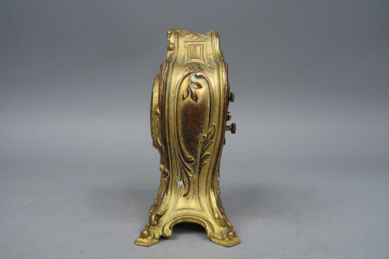 Pendulette en bronze doré à décor d'enroulements, volutes feuillagées et coquil…