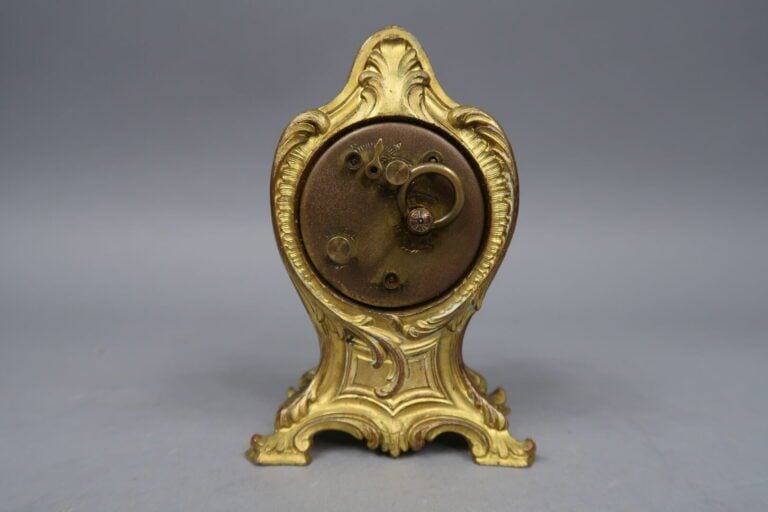 Pendulette en bronze doré à décor d'enroulements, volutes feuillagées et coquil…