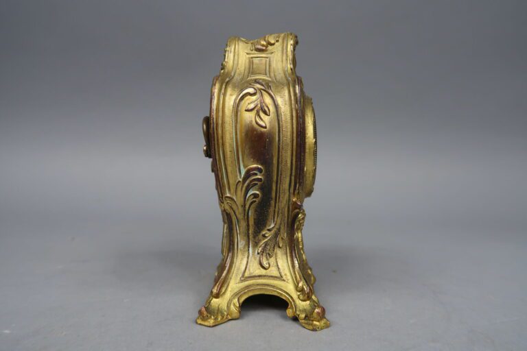 Pendulette en bronze doré à décor d'enroulements, volutes feuillagées et coquil…