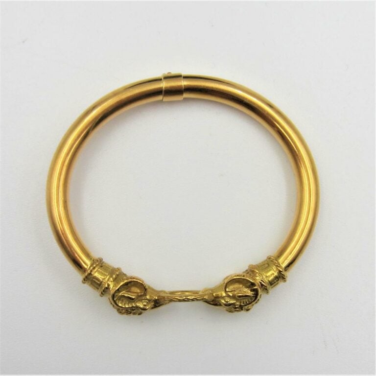 BRACELET tubulaire rigide ouvrant en or jaune (750 millièmes) terminé par deux…