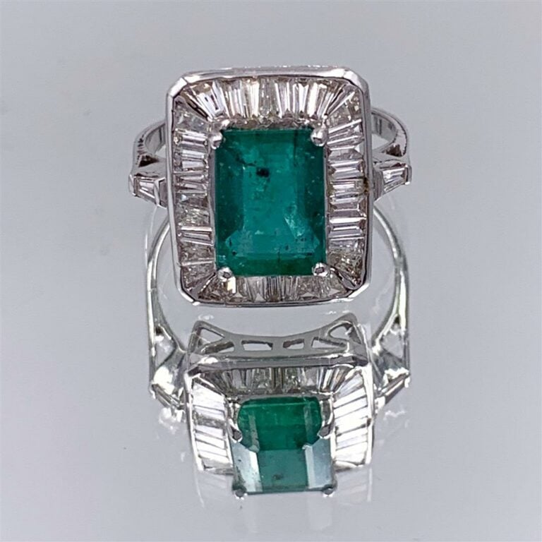 BAGUE en or gris (750 millièmes) serti d'une émeraude taillée à dégrées, entour…