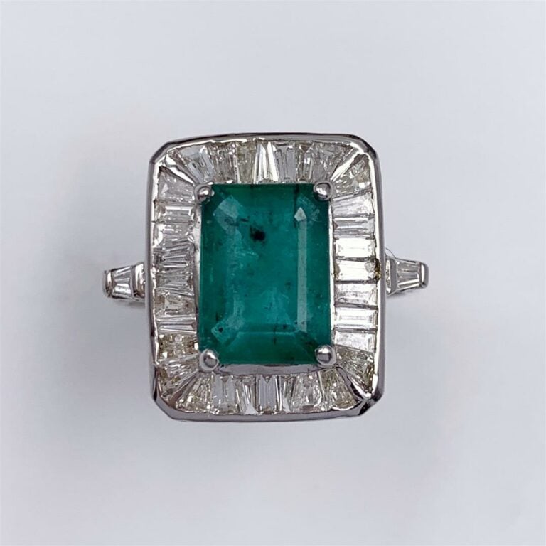 BAGUE en or gris (750 millièmes) serti d'une émeraude taillée à dégrées, entour…