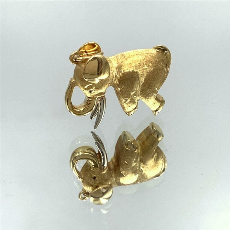 BRELOQUE « éléphant assis » en or jaune (750 millièmes) finement guilloché. - L…