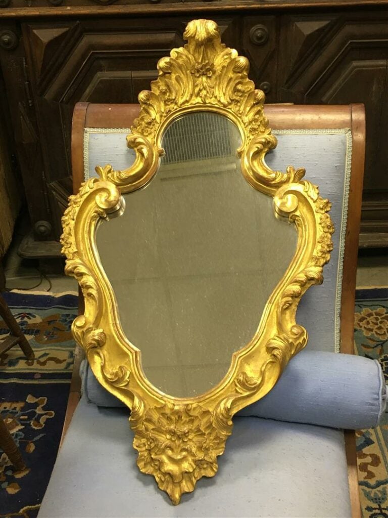 REGROUPE LOT 96 / Miroir de forme mouvementée en bois doré.