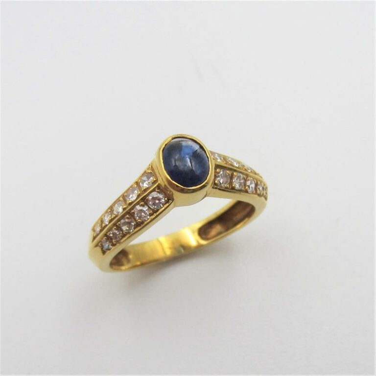 BAGUE en or jaune (750 millièmes) à motif de « V », centrée d'un saphir cabocho…