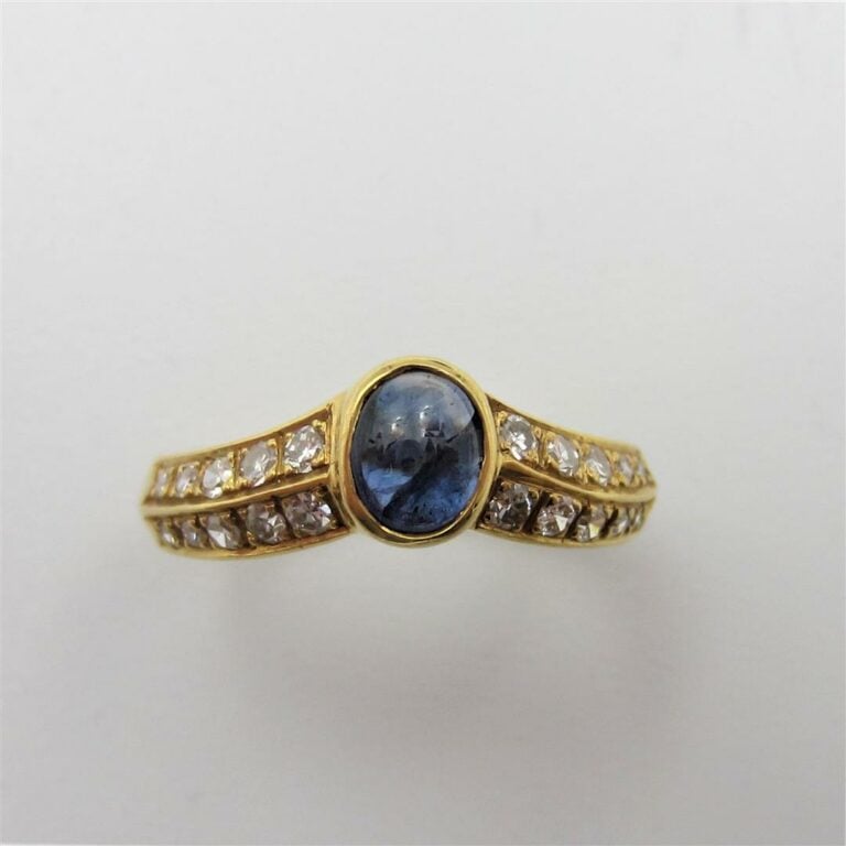 BAGUE en or jaune (750 millièmes) à motif de « V », centrée d'un saphir cabocho…