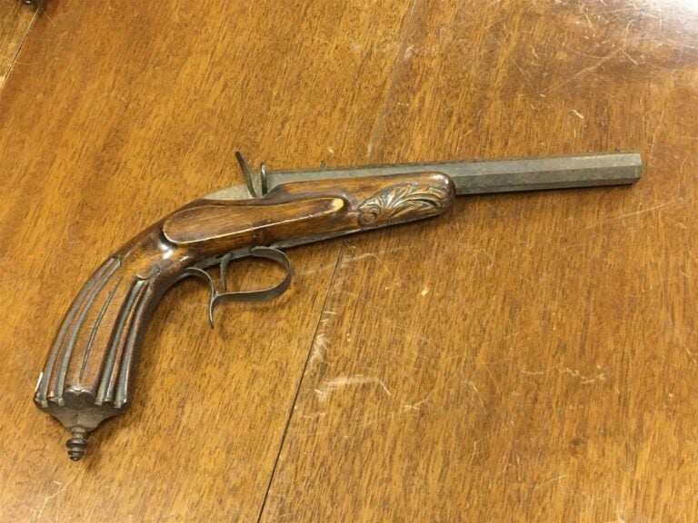 Pistolet à percussion à crosse en noyer à décor floral. - Longueur: 35 cm.