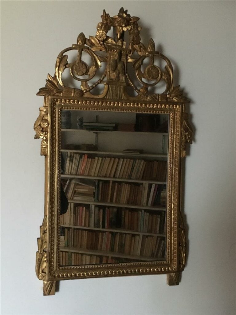 Miroir en bois doré, la vue encadrée d'un rang de perles et d'une frise de feui…