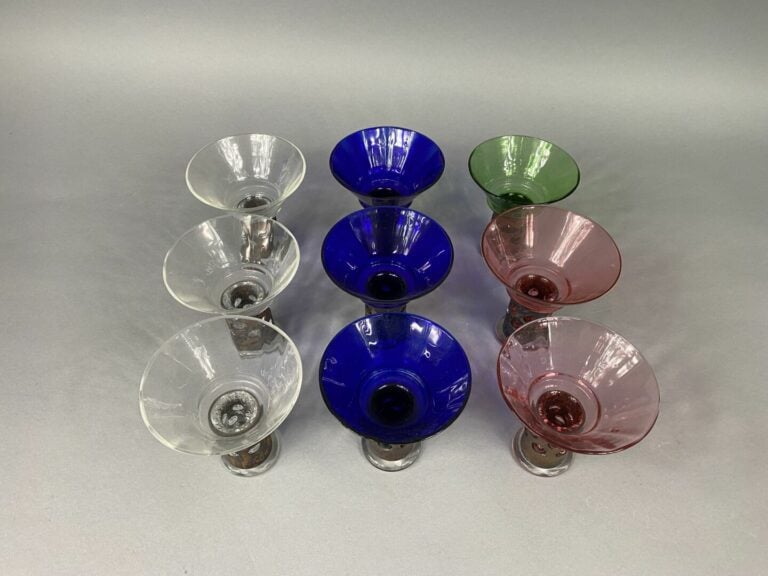 Suite de neuf coupes en verre coloré rose, vert, bleu ou transparent - Le pied…