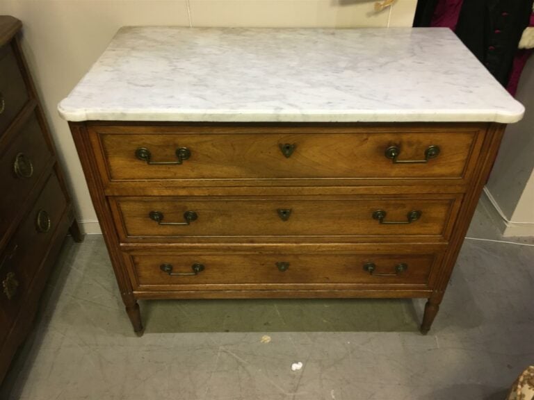 Commode en bois naturel mouluré, trois tiroirs en façade sur trois rangs. - Sty…