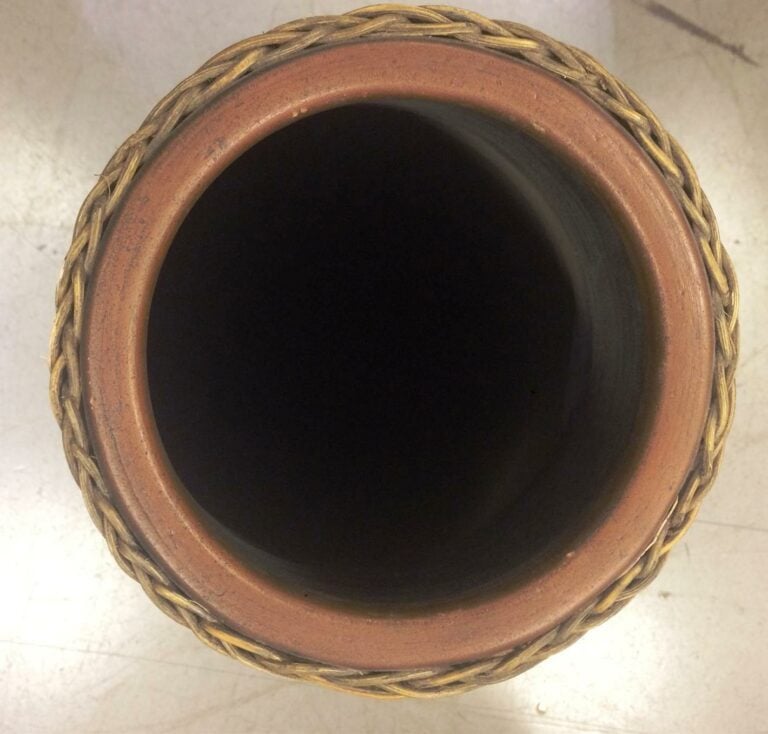 Grand vase de forme ovoïde en terre cuite, l'extérieur en rotin tressé à motifs…