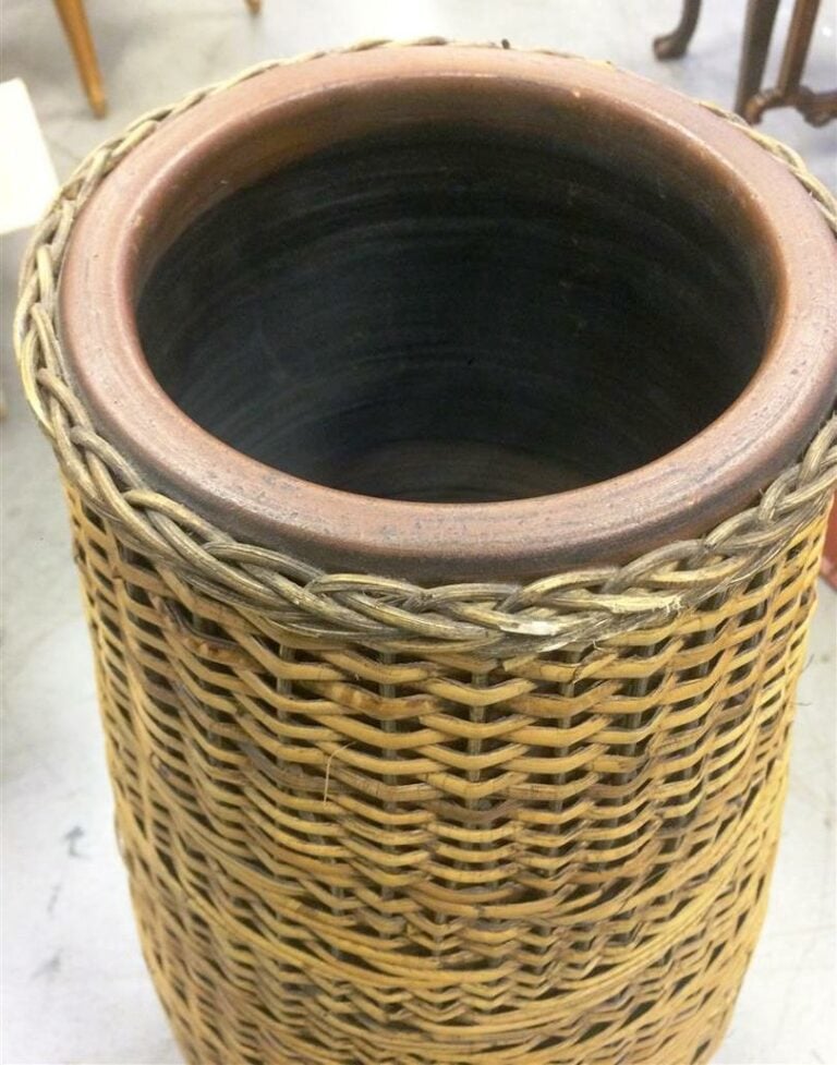 Grand vase de forme ovoïde en terre cuite, l'extérieur en rotin tressé à motifs…