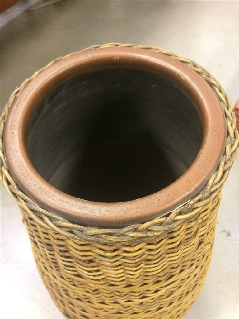 Grand vase de forme ovoïde en terre cuite, l'extérieur en rotin tressé à motifs…