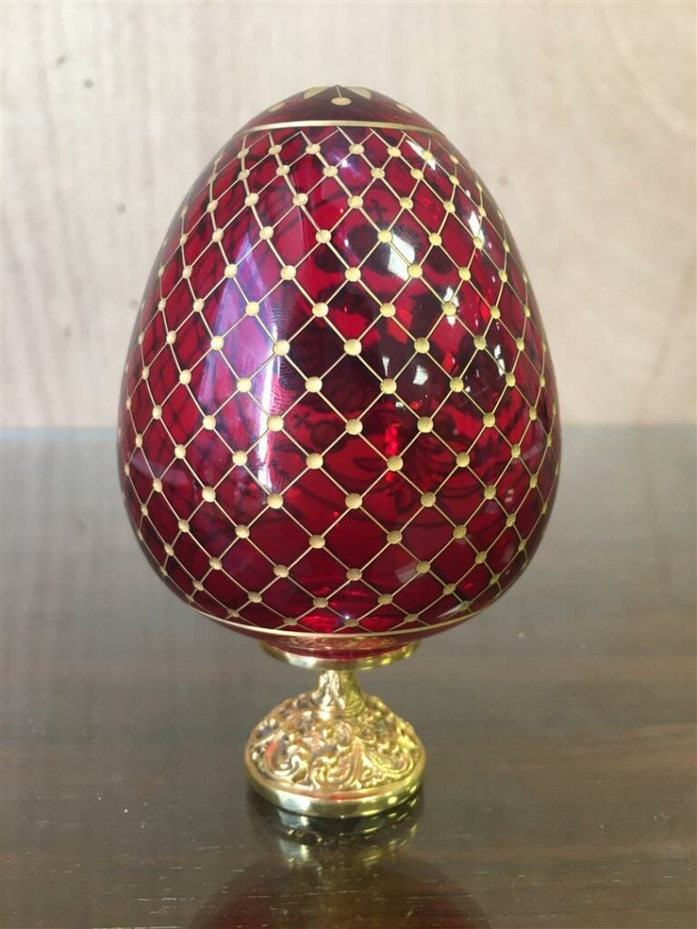 FABERGE. - Oeuf en cristal taillé rouge, sur son socle en métal doré signé et n…