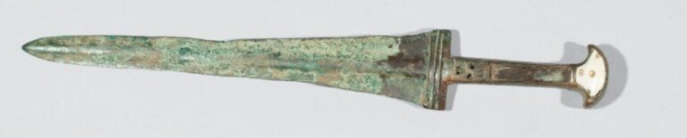 Dague à lame triangulaire et manche anciennement incrusté de pierre blanche. -…