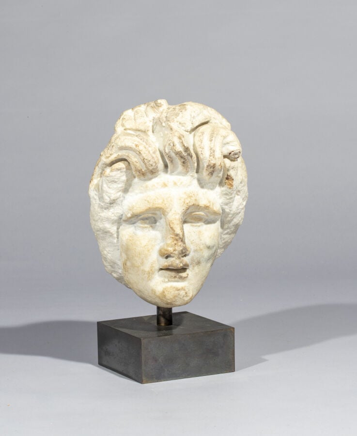 Tête de femme à la coiffure composée de longues mèches ébouriffées. Il s'agit d…