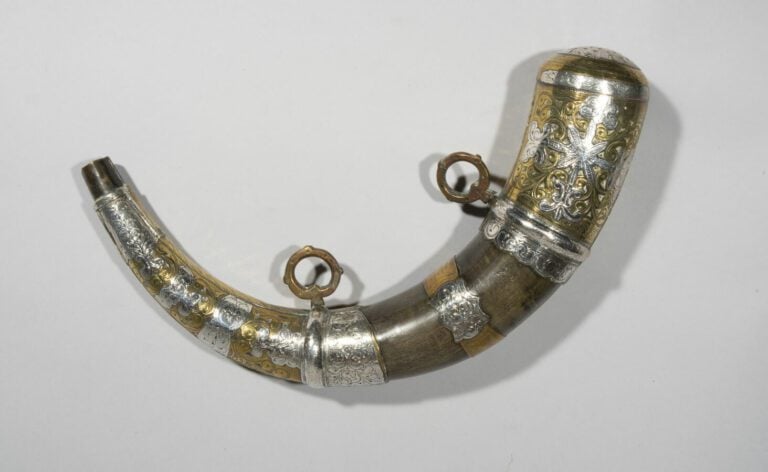 Poire à poudre en corne garnie de plaque d'argent et de cuivre ciselés de motif…