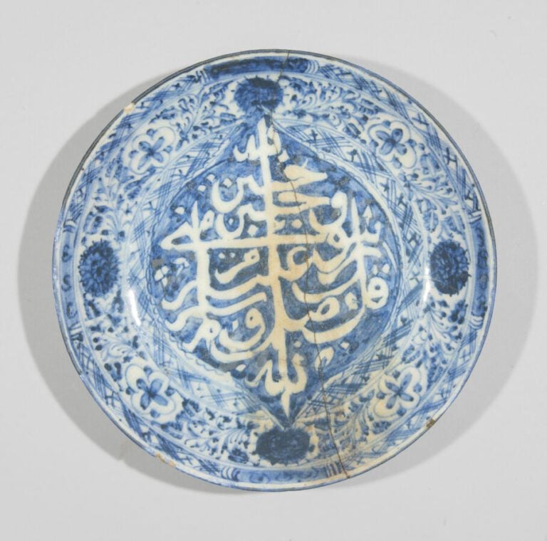 Plat bleu-blanc à décor calligraphique et floral - Pâte siliceuse à décor bleu-…