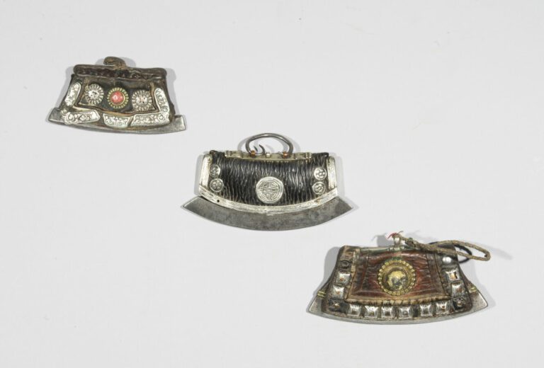 Trois briquets - Acier et cuir orné de plaques d'argent et de métal à décor rep…