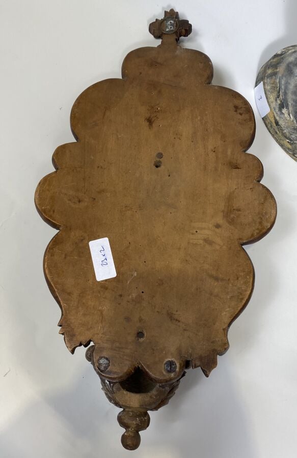 BENITIER en bois sculpté d'une tête d'angelot dans une couronne laurée sur un f…