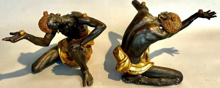 Paire de nubiens en bois noirci et or servant support de table. H : 48 cm.