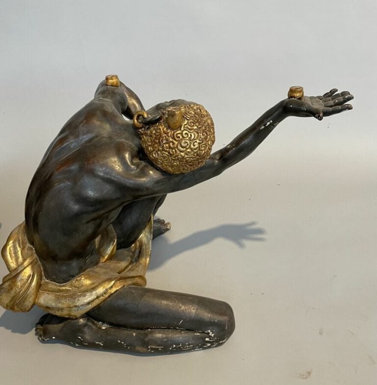 Paire de nubiens en bois noirci et or servant support de table. H : 48 cm.