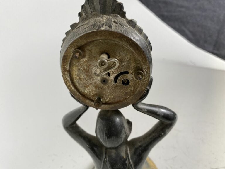 PENDULETTE sous la forme d'une femme agenouillée en métal supportant une pendul…