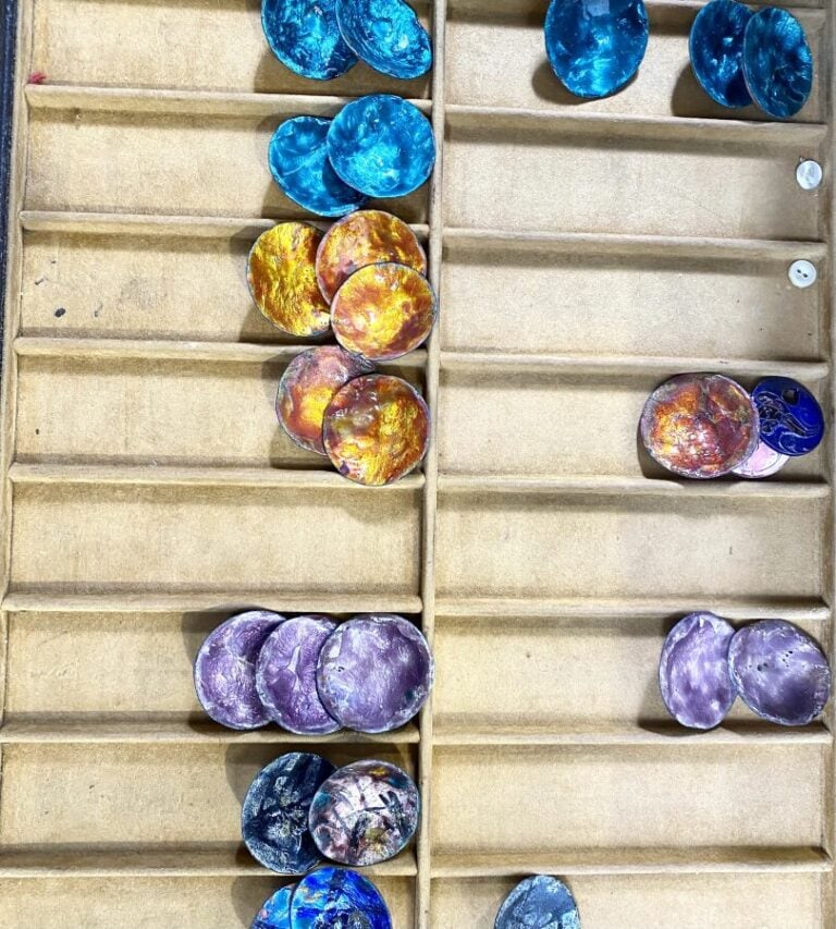 Coffret comprenant divers boutons anciens et des couteaux (manches en nacre).