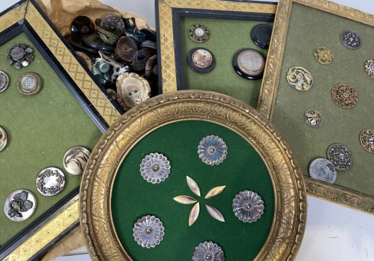 Lot de plaques de boutons anciens (dont cadre rond) et boîte bleue allongée.