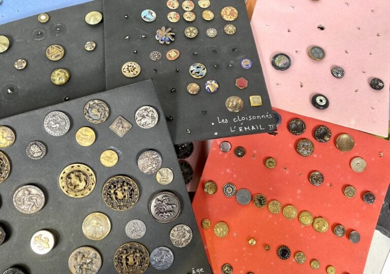 Lot de plaques de boutons anciens (dont cadre rond) et boîte bleue allongée.