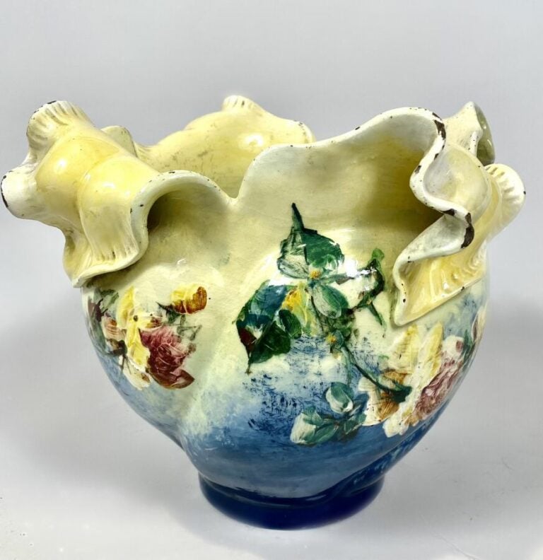 CACHE-POT en faïence polychrome à décor émaillé de fleurs ; le col formant péta…