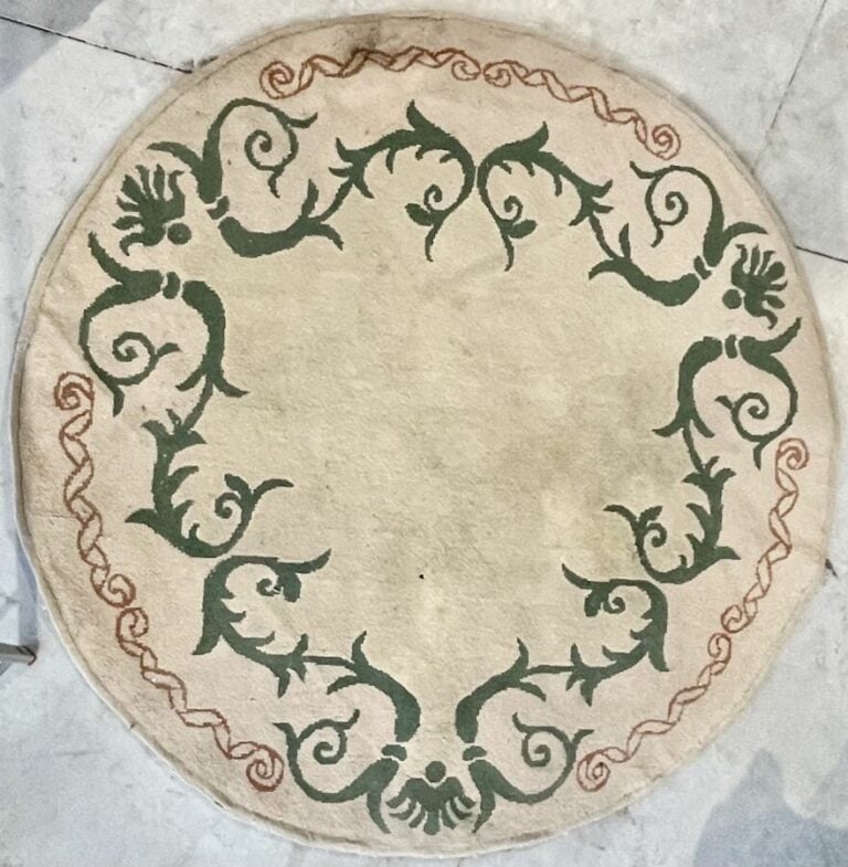 TAPIS rond en laine beige à décor de frises vertes. Dans - l'état. D : 186 cm.…