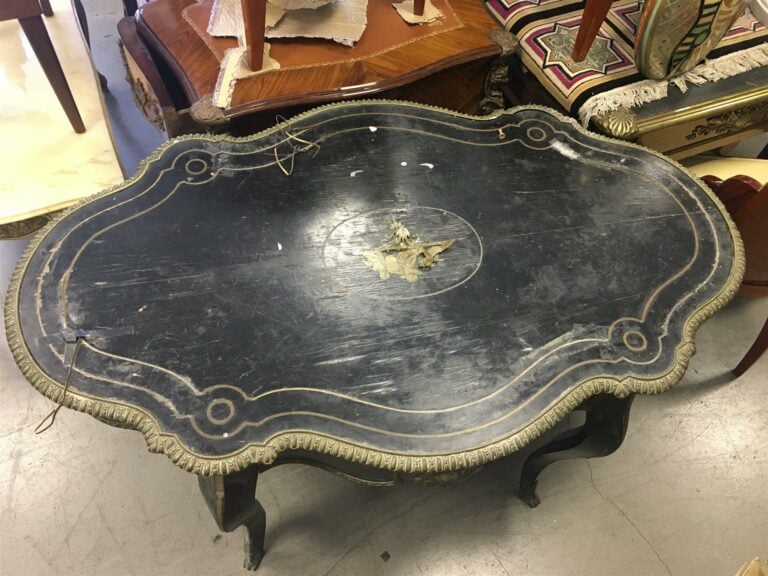 Table de milieu en bois noirci, le platau de forme violonée, pieds en console,…