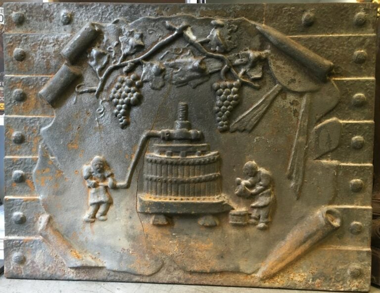 Plaque de cheminée en fonte représentant des vendangeurs actionnant un pressoir…