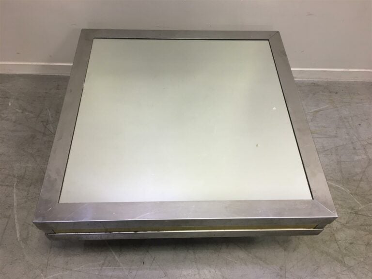 Table basse en inox et laiton, plateau à fond de glace. - Hauteur: 34 cm. ; Lon…