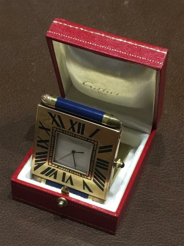 CARTIER. - Réveil de voyage pliable, le boitier en bronze, mouvement à quartz.…
