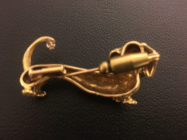 Broche en or jaune 750/1000 à décor d'un teckel, orné de deux brillants et deux…
