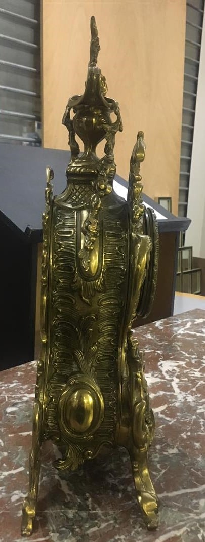 Pendule de cheminée en bronze doré, à riche décor rocaille ajouré (avec sa clef…