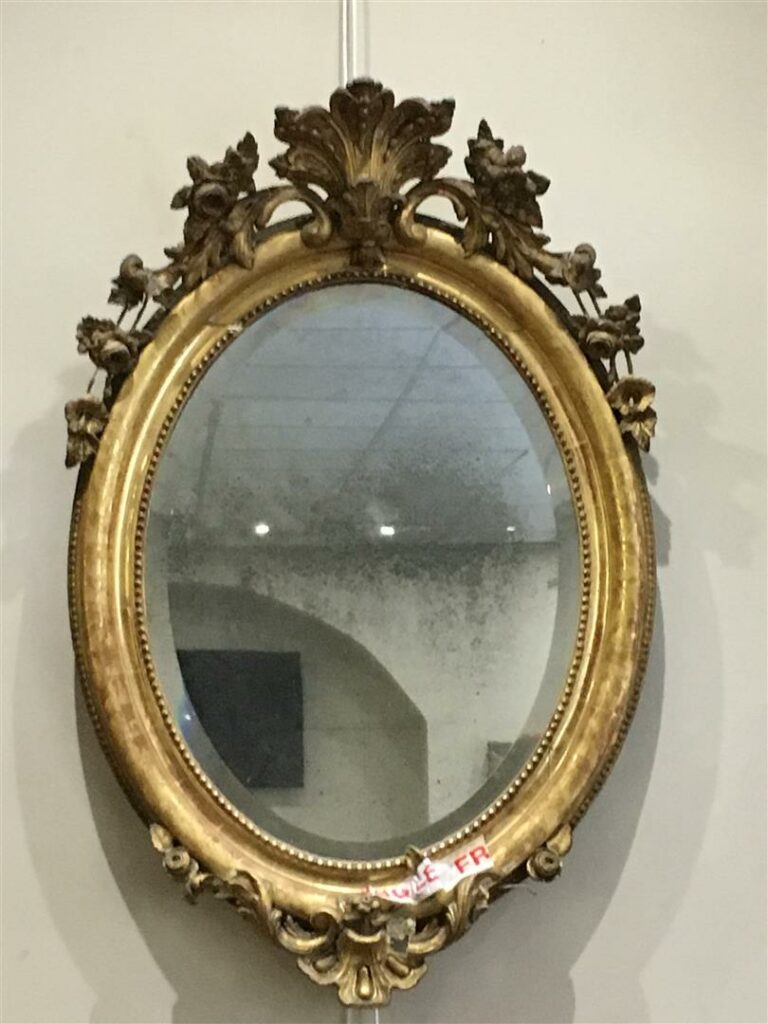 Miroir ovale en bois mouluré et doré, le contour du miroir à rang de perles et…