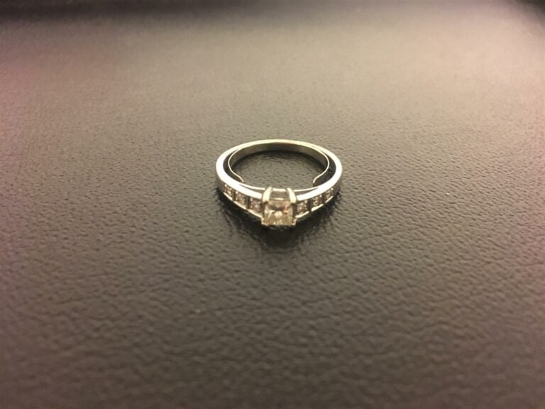 Alliance en or blanc ornée d'un diamant de taille princesse, avec de chaque cot…
