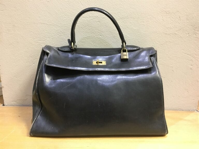 Sac HERMES modèle Kelly en cuir noir (usures importantes).