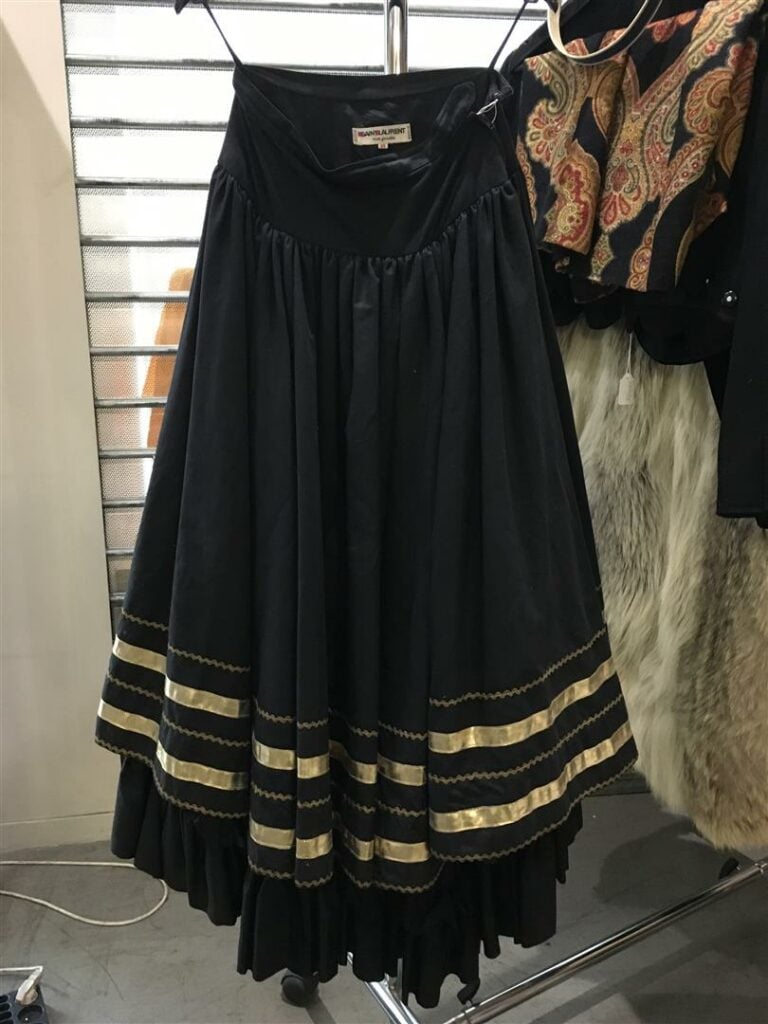 SAINT LAURENT Jupe noire avec liseré doré en partie basse.