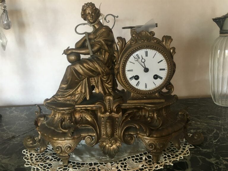 Pendule en régule à décor rocaille, le cadran émaillé blanc flanqué d'une figur…