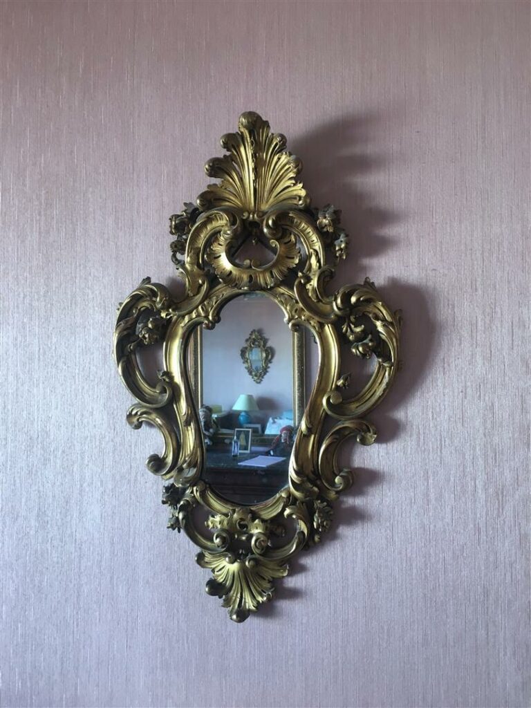 Paire de miroirs en bois et stuc doré à riche décor rocaille. - 74 x 46 cm.