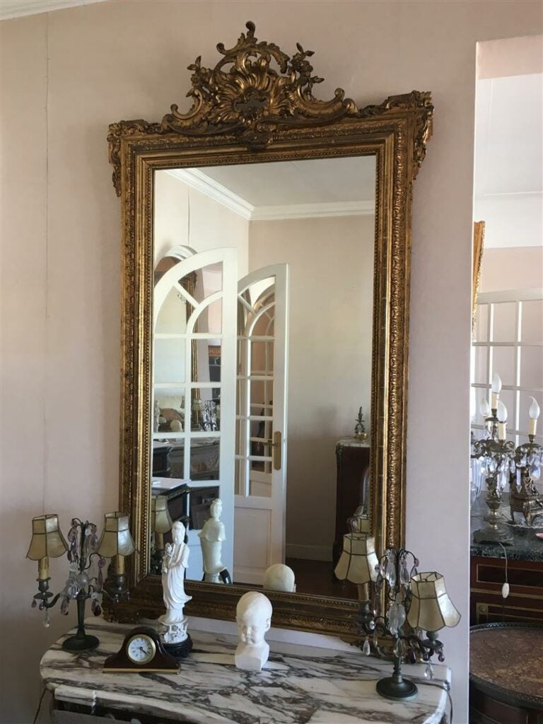 Miroir de cheminée en bois stuqué et doré, le fronton orné d'une coquille. - St…
