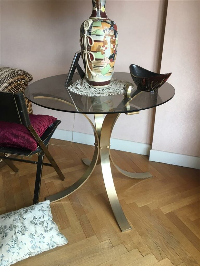 Table-guéridon, le plateau en verre, le piètement formé de lames d'acier recour…