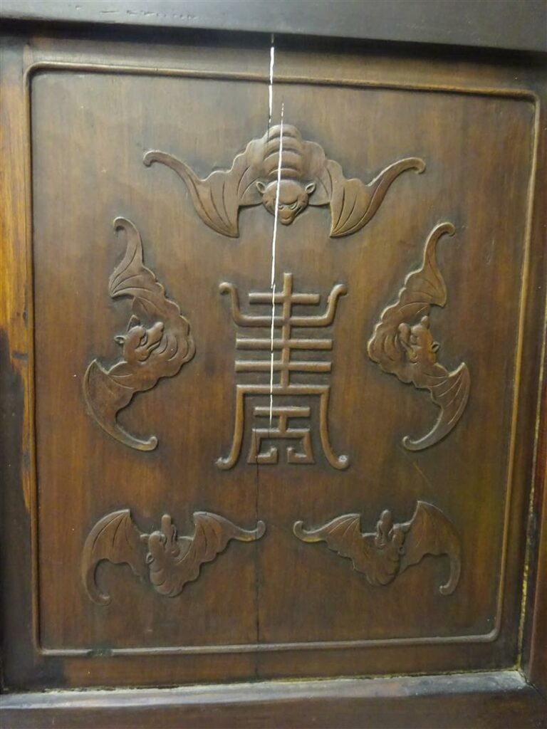 Buffet bas en bois patiné, ouvrant à deux portes sculptées de chiens de fô dans…