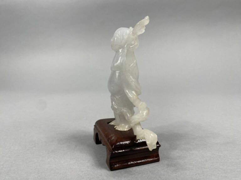 Chine - Sujet en jade blanc sculpté figurant un magot debout tenant un collier…
