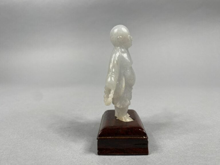 Chine - Sujet en jade blanc sculpté figurant un magot debout tenant un collier…